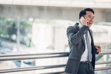 Asian businessman using mobile phone outside of office