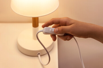Switch off Light of Lamp. Woman Hand Turn off Lamp in bedroom, concept Save Energy.