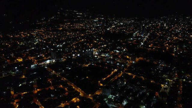 high drone shot of the city of ibagu&eacute; tolima at night with many lights and lots of color