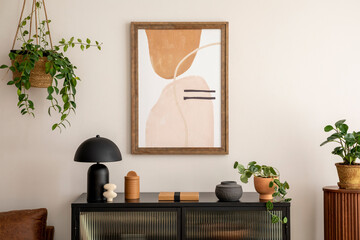 Creative composition of living room interior with mock up poster frame,  black commode, modern lamp, books, plants, decoration and personal accessories. Home decor. Template. 