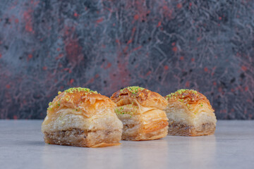 Sweet baklava with pistachios on marble background