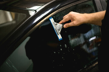 A series of tinting car windows. Installation of tinting film on the car glass. Specialist in the...