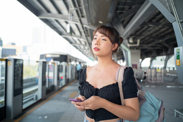 Fototapeta premium Beautiful asian woman use smartphone travel in city train