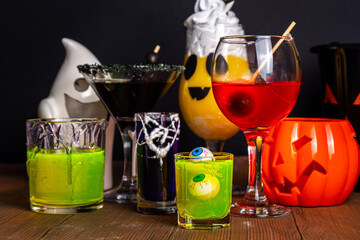 Halloween party bar festive drink, set various colorful alcohol, non-alcohol cocktails, drinks with halloween characters costumes hands, holiday decor and symbols