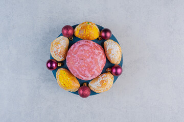 Homemade various biscuits and Christmas baubles on blue board
