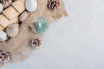 Cookies bundled on a piece of cloth amid christmas decorations on marble background