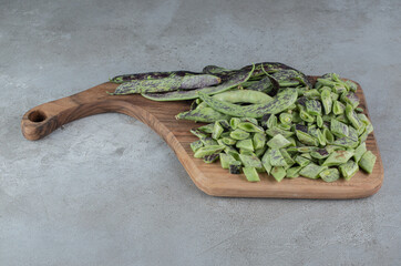 Uncooked fresh peas isolated on a wooden board