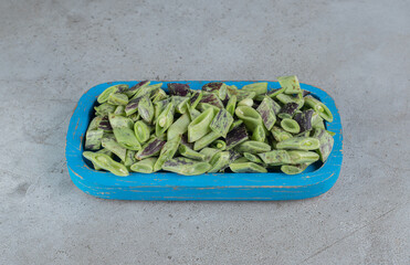 Uncooked fresh peas isolated on a blue board