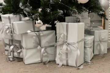 Beautiful Christmas gifts under fir tree on floor in room