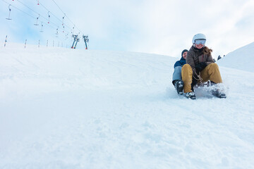 Fototapeta na wymiar Crazy happy friends having fun with sledding on snow high mountains - Winter lifestyle concept