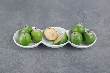 Delicious feijoa fruits in white bowls