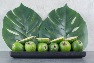 Tasty feijoa fruits on black plate