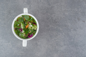 Bowl of vegetable soup on marble background