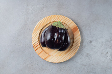 A big purple eggplant vegetable on a wooden board