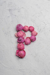 letter P outlined with pink flowers on a white background
