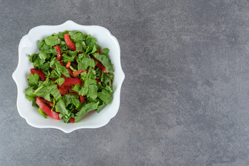 Bowl of fresh salad on marble background