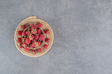 Obraz na płótnie Canvas Bowl of tasty red raspberries on marble background