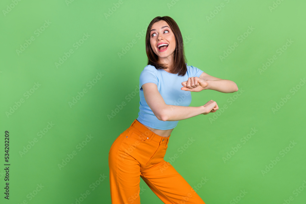 Wall mural Photo of overjoyed cheerful girl have fun good mood dancing partying isolated on green color background