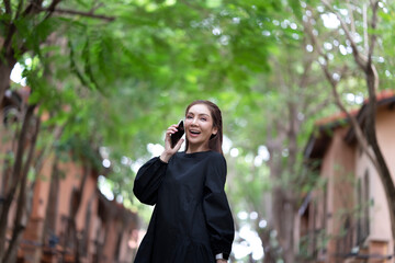 Young cheerful woman receive international calls while traveling abroad, roaming call from a family asking about trip and planning schedule for next few days while walking outside hotel