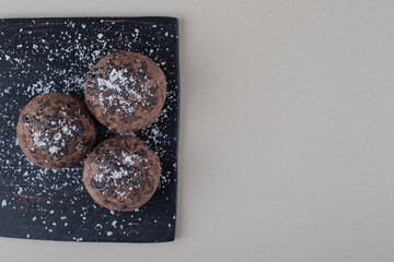 Chocolate topped cookies on a black board on marble background