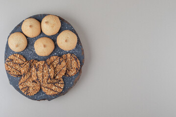 Chocolate coated wafers stacked on a black platter on marble background