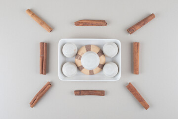 Arrangement of a cookie platter and cinnamon sticks on marble background