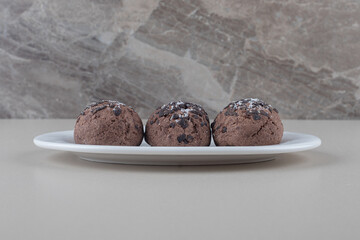 A serving of chocolate cookies on a platter on marble background