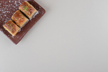 Turkish bakhlavas lined up on a platter on marble background
