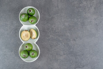 Delicious feijoa fruits in white bowls