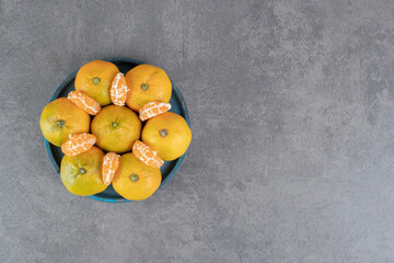Bunch of delicious tangerines on blue plate