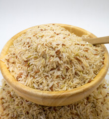 Jasmine rice seeds in a cup Rice color background with wooden spoon