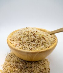 Jasmine rice seeds in a cup Rice color background with wooden spoon
