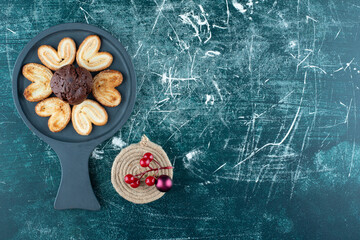 A dark board with chocolate muffin and cookies