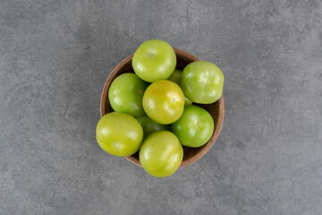 Fresh green tomatoes in wooden bowl