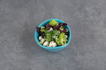 Bowl of vegetable salad on marble background