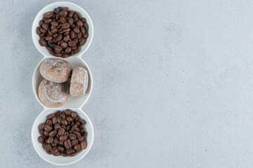 Obraz na płótnie Canvas Serving platter with coffee beans and cookies on marble background