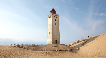 Fototapeta na wymiar Lokken, Denmark - August 24, 2022: People at the popular Rubjerg Knude Lighthouse in Jutland.