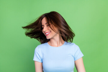 Photo of gorgeous cheerful girl closed eyes toothy smile flying hair isolated on green color background