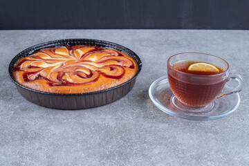 Delicious pie with berry and cup of tea on marble background