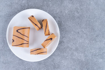 Slices of chocolate roll cake on white plate