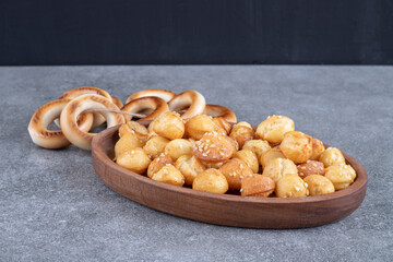 Round crackers and plate full of salty crackers on marble surface