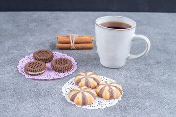 Assortment of sweets and cup of tea on marble background