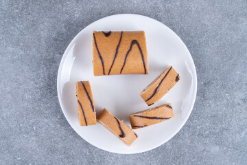 Slices of chocolate roll cake on white plate