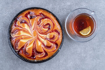 Delicious pie with berry and cup of tea on marble background