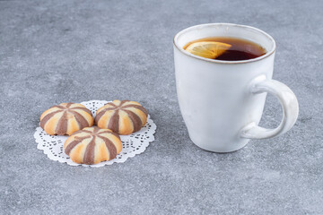 Zebra pattern biscuits and cup of tea on marble surface
