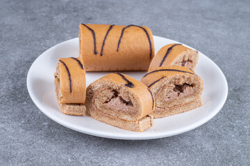 Slices of chocolate roll cake on white plate