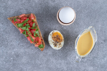 Delicious toast with boiled egg on a gray background