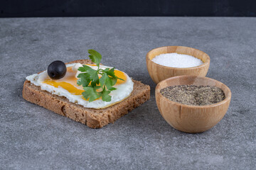 Toast with wooden bowls of salt and pepper