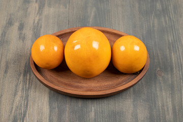 Delicious juicy persimmons on a wooden board