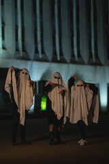 A man dressed in a ghost costume with glasses walks around the city. Halloween holiday. Masquerade. Ghost concept. Article about Halloween. Ghost article. Mystic